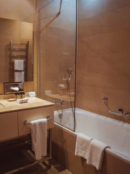 Hotel bathroom with shower, mirror and ventilation area
