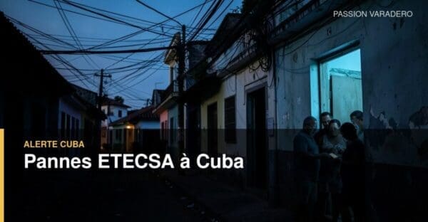 Rue cubaine à la tombée du jour pendant une panne électrique, avec un habitant consultant son téléphone près de lignes de télécommunications